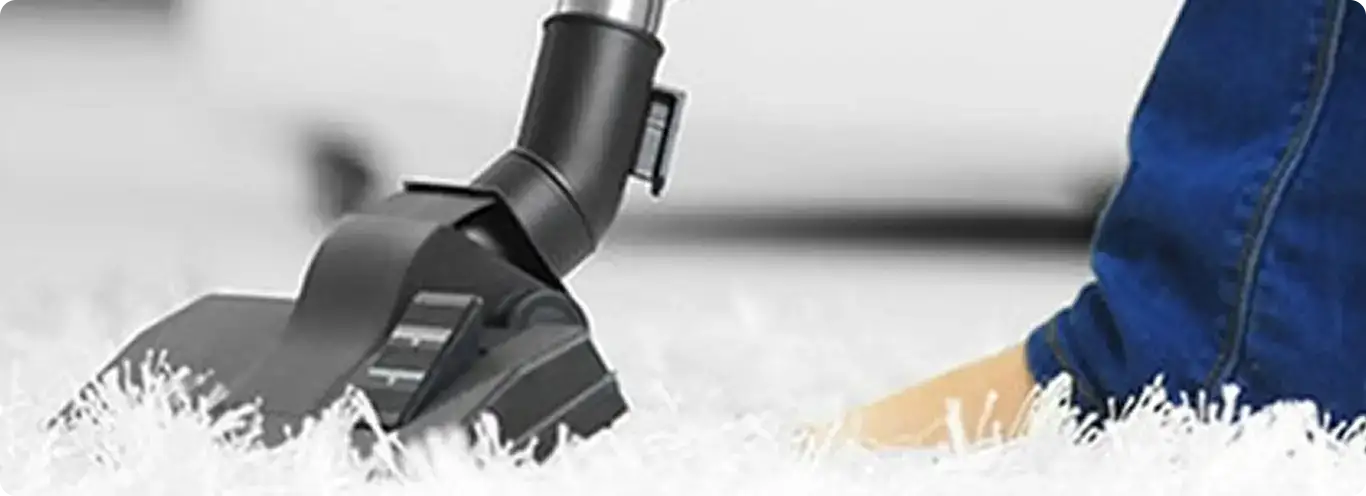 Close-up of a professional vacuuming a white carpet in Rockton.